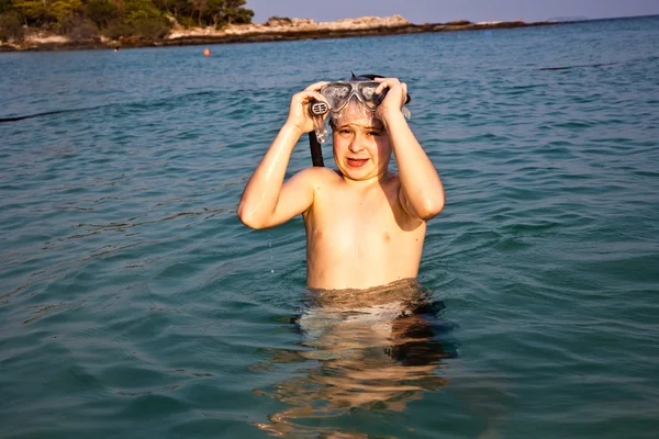 Joven niño está de pie en el hermoso mar claro, disfrutando de la w —  Fotos de Stock