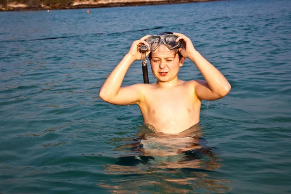 Молодий хлопчик стоїть в прекрасному чистому морі, насолоджуючись w — стокове фото