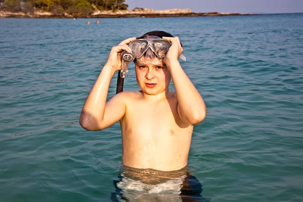 Young boy is standing in the beautiful clear sea, enjoying the w — Stock Photo, Image