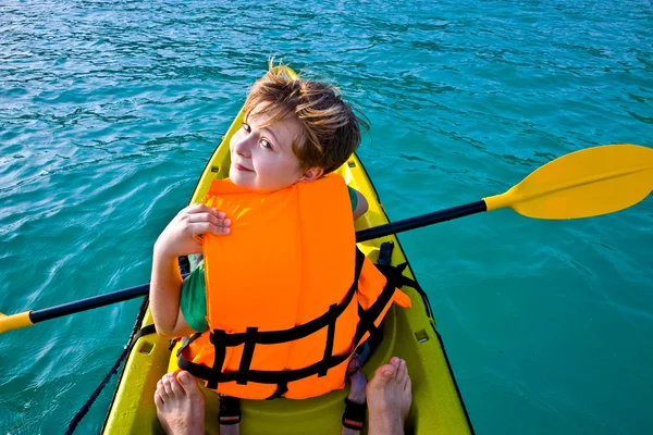 Αγόρι κουπιά σε ένα κανό στον ωκεανό με ασφάλεια δυτικά — Φωτογραφία Αρχείου
