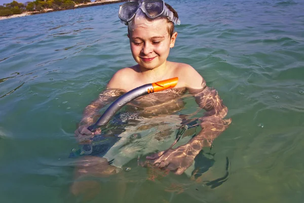 Мальчик любит плавать с трубкой в чистой воде — стоковое фото