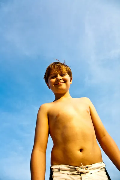 Szczęśliwy uśmiechający się młody chłopak z niebieski niebo Irysy się jego — Zdjęcie stockowe