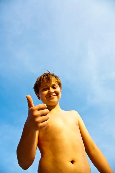 Felice sorridente giovane ragazzo con sfondo blu cielo iris su la sua un — Foto Stock