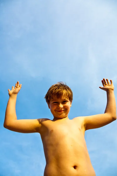 Boldog mosolygó fiatal fiú, a háttér kék ég íriszek, ő egy — Stock Fotó