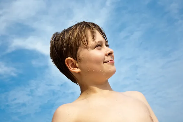 Happy young boy with brown hair and eyes at the beach is smiling — Stock Photo, Image