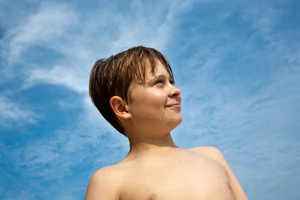 Niño feliz con el pelo castaño y los ojos en la playa sonríe —  Fotos de Stock