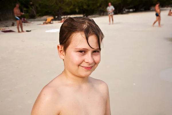 Gelukkige jongen met bruin natte haren is glimlachend en genieten van de — Stockfoto