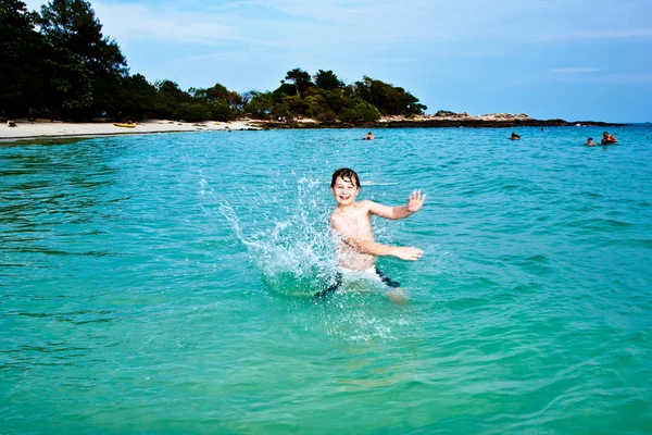 Young happy boy with brown hair enjoys playing in the beautiful — Stock Photo, Image