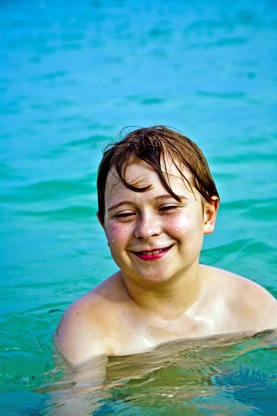 Joven niño feliz con el pelo castaño disfruta jugando en la hermosa —  Fotos de Stock