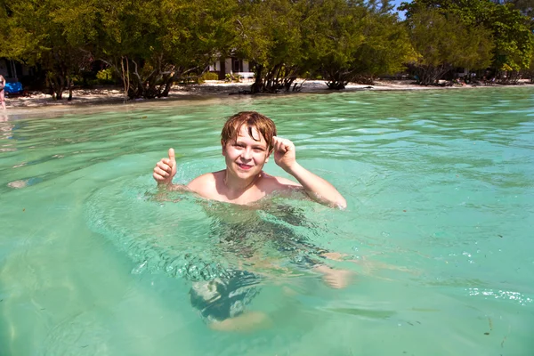 Jonge jongen zwemmen in de heldere warme zee geniet en heeft leuke — Stockfoto
