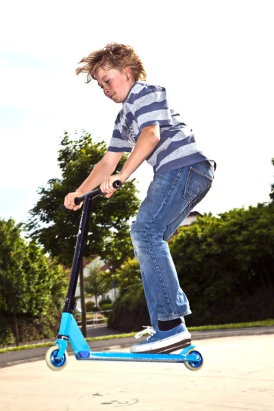 Мальчик любит кататься на скутере в скейт-парке — стоковое фото