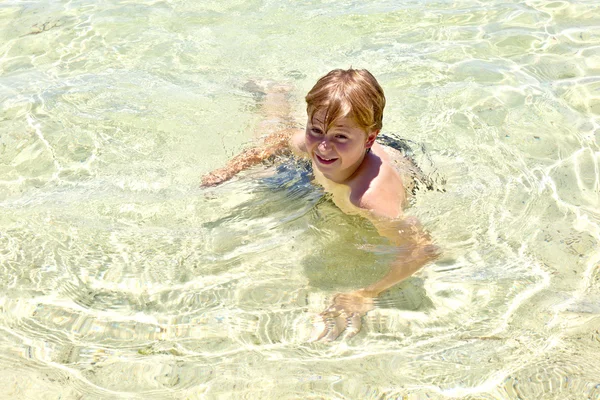 在海洋中的男孩在美丽清澈的水中游泳 — 图库照片