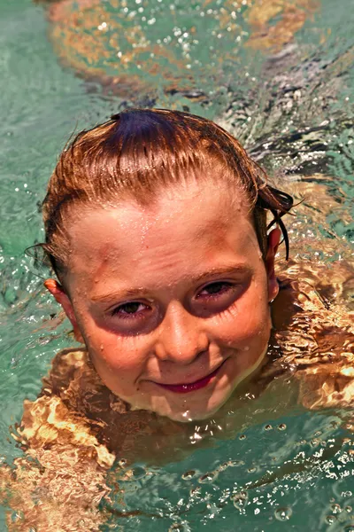 Ragazzo nell'oceano nuota in bella acqua limpida — Foto Stock