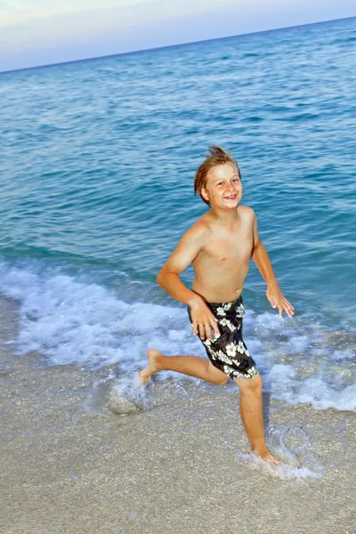 Fiú jogging, a gyönyörű tengerparton — Stock Fotó