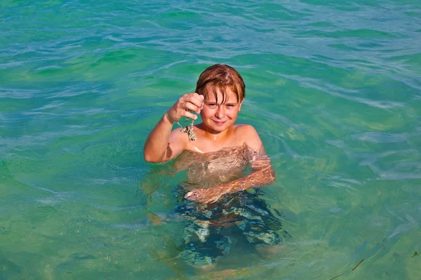 Garçon jouit de l'eau claire dans l'océan — Photo