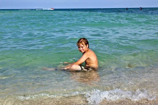 Jongen geniet van het heldere water in de Oceaan — Stockfoto