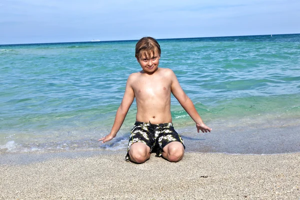 Niño disfruta del agua clara en el océano — Foto de Stock