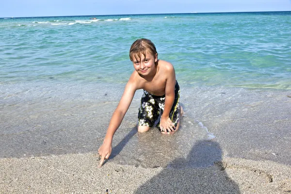 Niño disfruta del agua clara en el océano —  Fotos de Stock