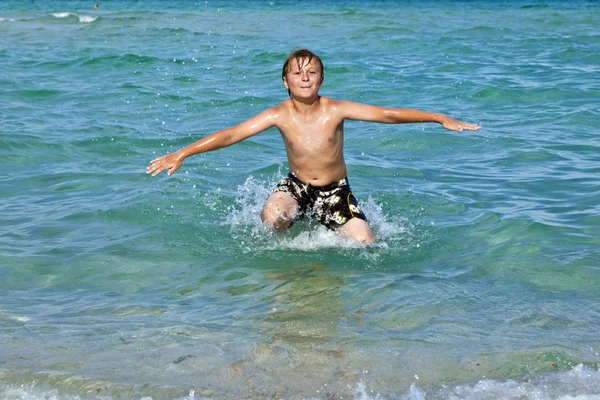 Pojken har det klara vattnet i havet — Stockfoto