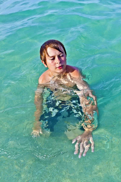 Menino goza da água limpa no oceano — Fotografia de Stock