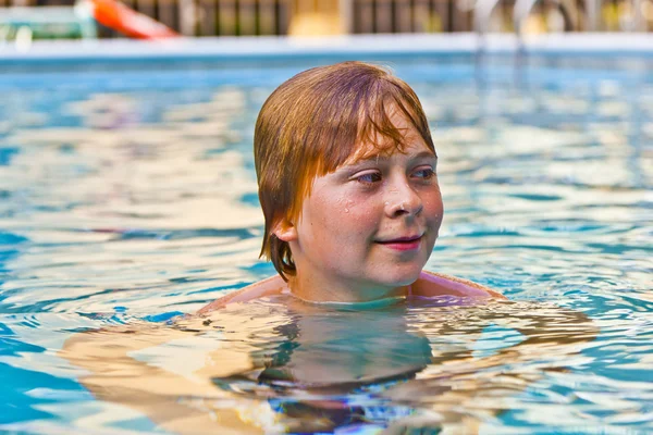 Garçon aime nager dans une piscine extérieure — Photo