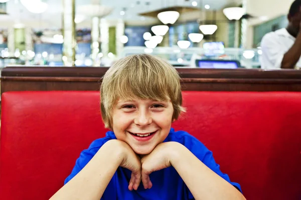 夜にダイナーで微笑む少年 — ストック写真