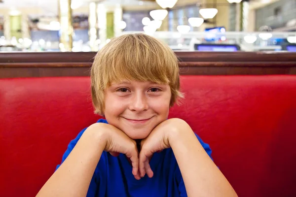 Menino sorridente em um restaurante à noite — Fotografia de Stock