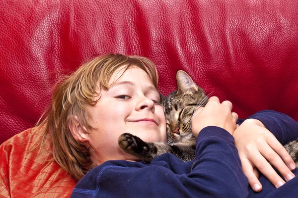 Jovem menino está abraçando com seu gato — Fotografia de Stock