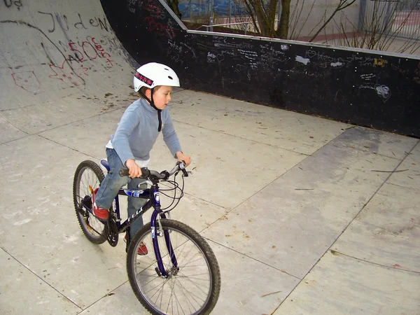 Chłopiec z jego rower górski trenuje sztuczki BMX w pół-pip — Zdjęcie stockowe
