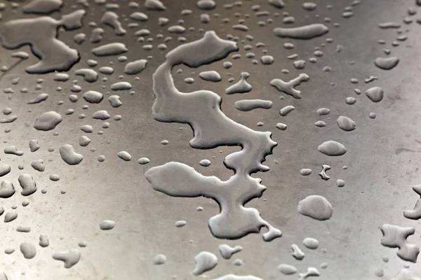 Vatten på silver metall tabell i harmonisk form — Stockfoto