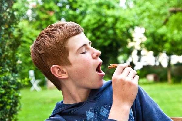 Hungriger Junge beißt in sein Brot — Stockfoto