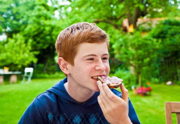 Junge isst im Garten — Stockfoto