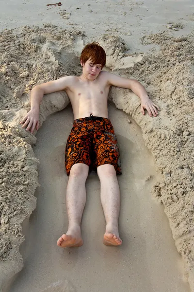 Jeune garçon couché sur la belle plage — Photo