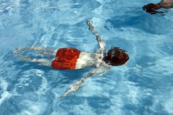 Chlapec se baví potápění v bazénu — Stock fotografie