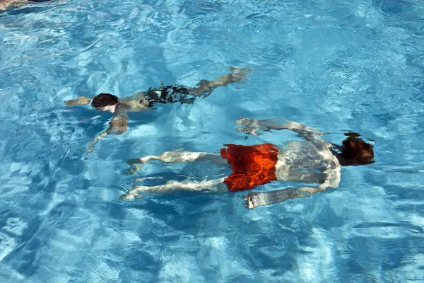 Boldog gyermekek búvárkodás a medencében — Stock Fotó