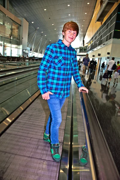 Jeune garçon sur un escalier mobile à l'intérieur de l'aéroport — Photo