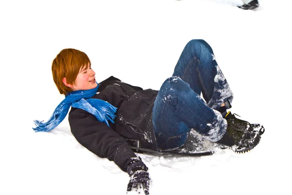Chłopiec sanki w dół wzgórza w śniegu — Zdjęcie stockowe