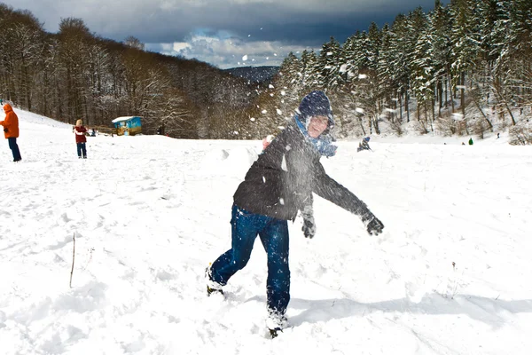 Діти мають снігову бійку в білій засніженій зоні — стокове фото