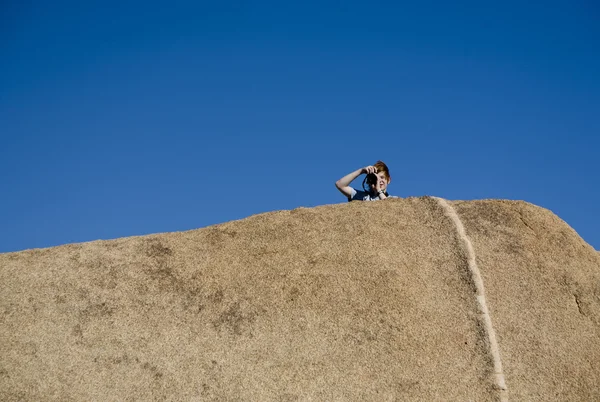 Boy is taking a picture from a rock at joshua tree national park — Stock Photo, Image