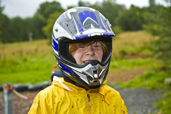 Ragazzo felice con casco al sentiero del kart — Foto Stock