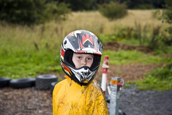 Rapaz feliz com capacete na trilha de kart — Fotografia de Stock