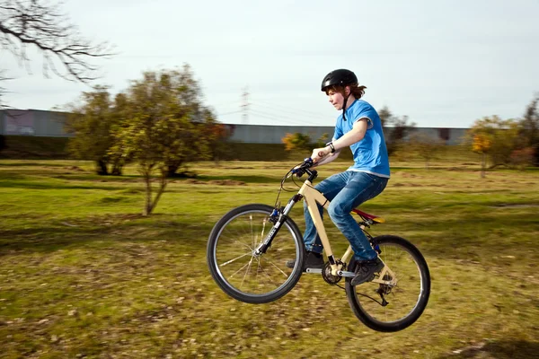 Мальчик едет на грязном велосипеде и гоняет в ландшафте — стоковое фото