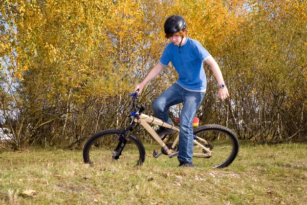 Joven niño está montando con la dirtbike y las carreras en el landscap — Foto de Stock