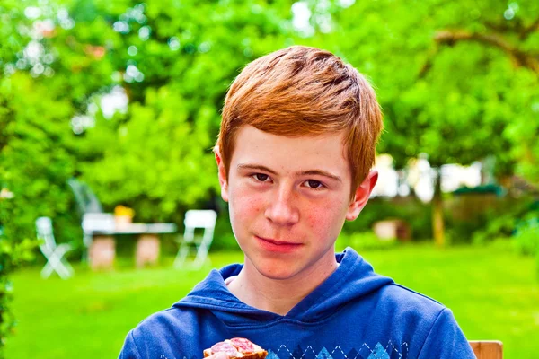 정원에서 빵을 먹는 소년 — 스톡 사진