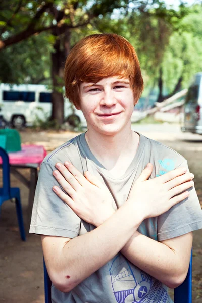 Niño con el pelo rojo y pico en la cara se ve feliz — Foto de Stock