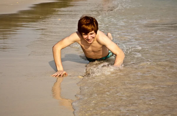 Rapaz bonito desfrutando da praia arenosa — Fotografia de Stock