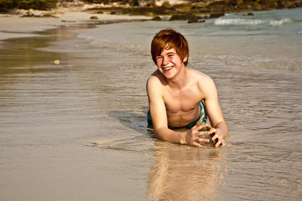 Rapaz bonito desfrutando da praia arenosa — Fotografia de Stock