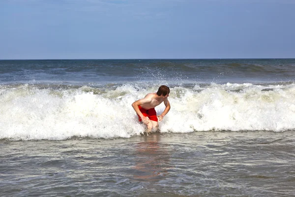 Ung pojke är kroppen surfa i vågorna — Stockfoto