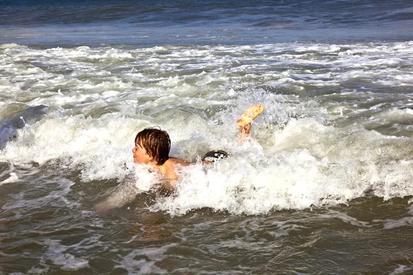 Νεαρό αγόρι κάνει σέρφινγκ στα κύματα του ωκεανού — Φωτογραφία Αρχείου