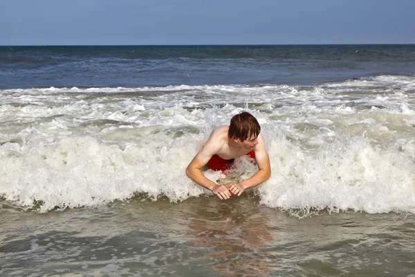 Joven chico es el cuerpo surfeando en las olas — Foto de Stock